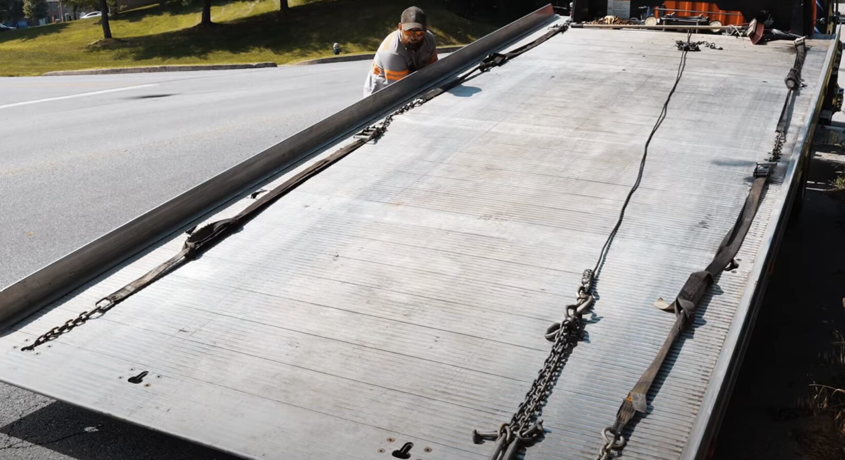 RightTouch Madera Towing - Professional flatbed towing operations Professional tow truck operator securing vehicle on flatbed